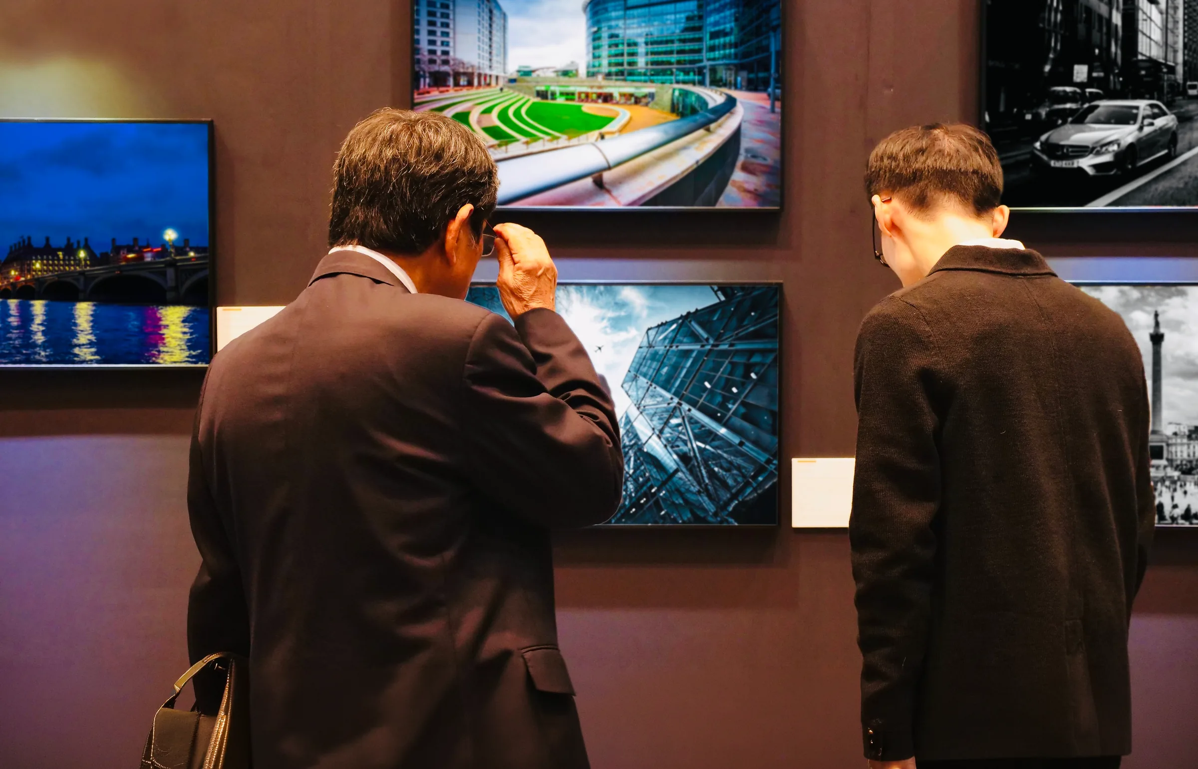 Due visitatori davanti alle fotografie in mostra